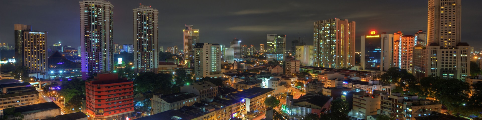 Un paisaje urbano nocturno con edificios e calles iluminadas.
