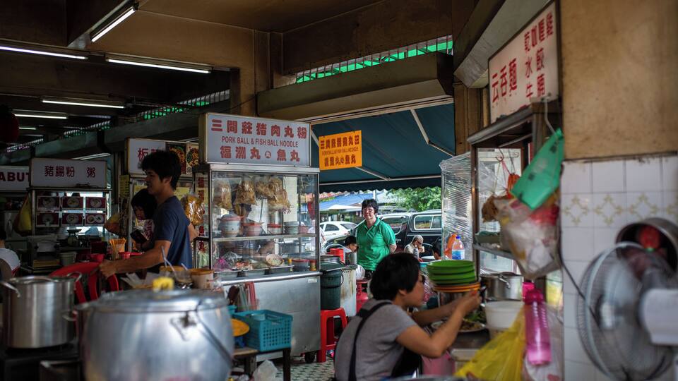 Ein lebhafter Markt mit Straßenküchen und Kochutensilien.