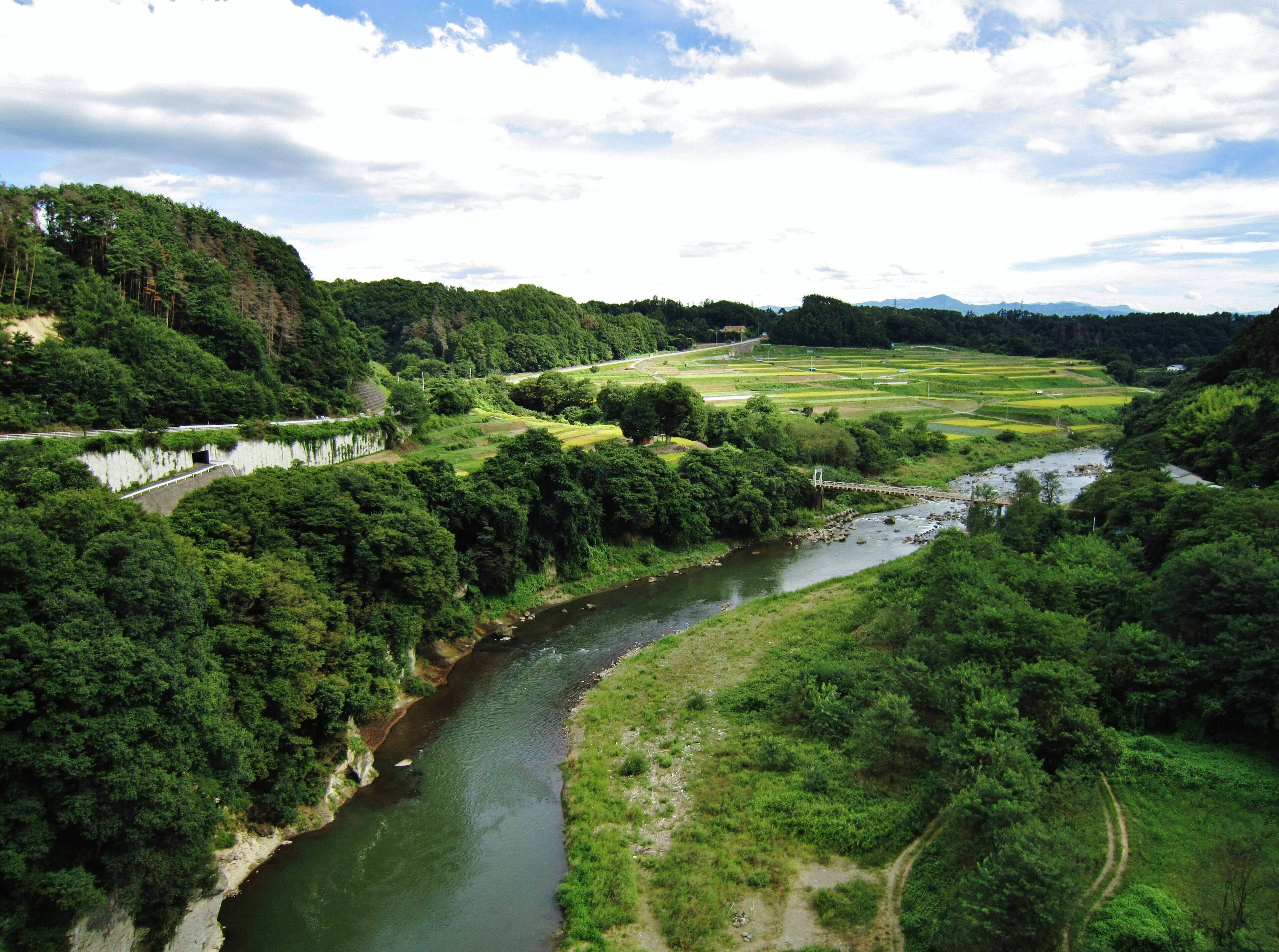 A river winding through a lush valley with dense forests and terraced fields.