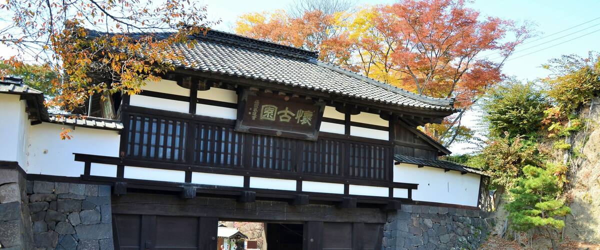 A traditional Japanese gate with a stone wall and wooden structure.
