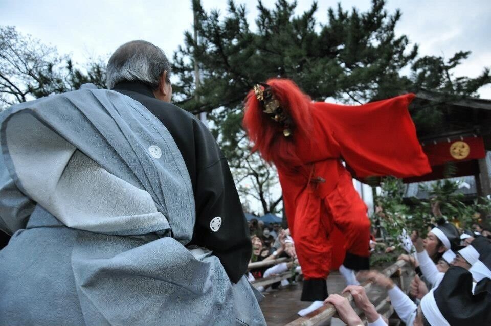 A person in a red costume performing in front of a crowd.