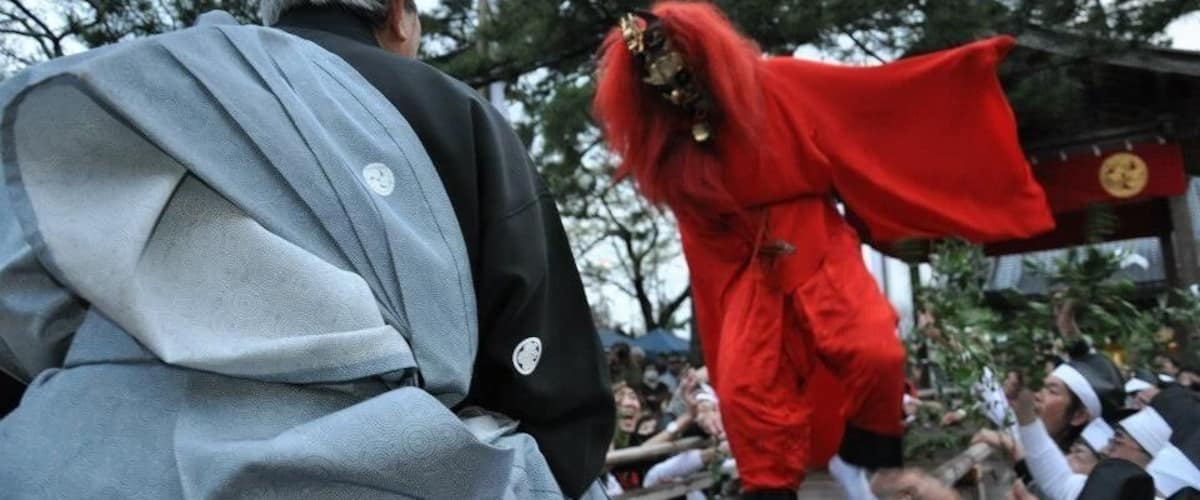 A person in a red costume performing in front of a crowd.