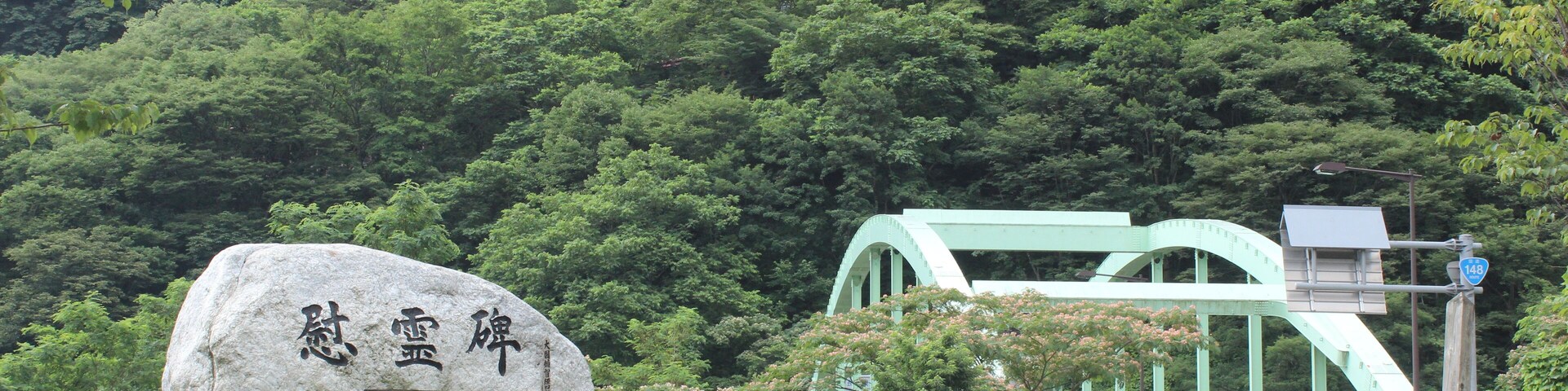 国界橋(1998年完成)と1996年に発生した蒲原沢土石流災害の慰霊碑。国道148号線。新潟-長野県境。