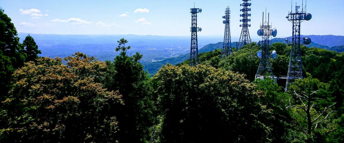 A mountainous landscape with multiple telecommunications towers.