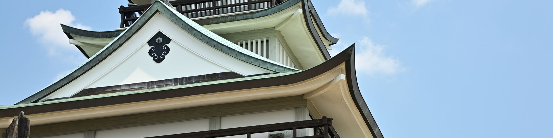 Un castillo japonés tradicional con varios niveles y techo verde.