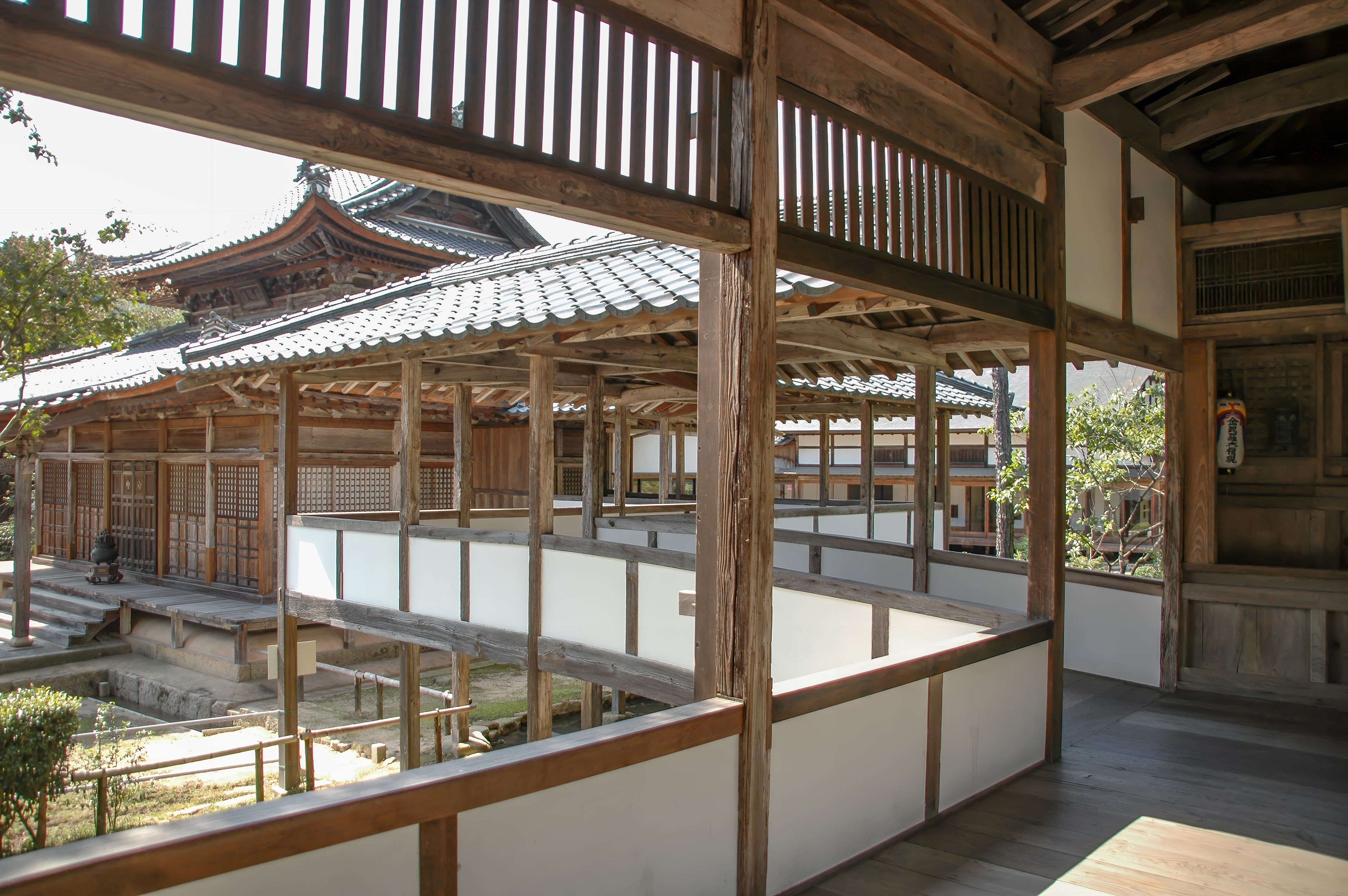 Un bâtiment traditionnel japonais, avec des poutres en bois et un toit recouvert de tuiles.