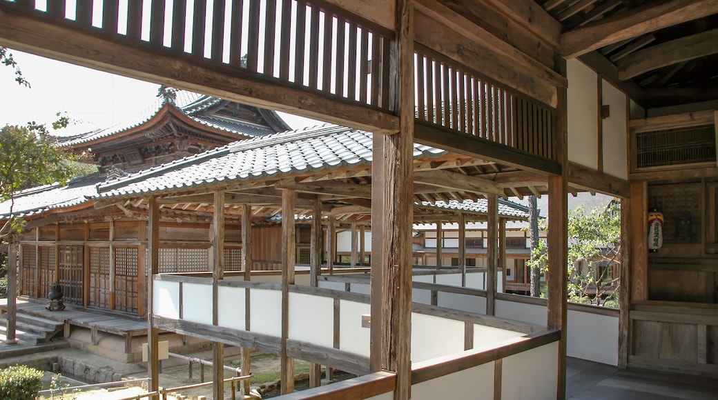 Un bâtiment traditionnel japonais, avec des poutres en bois et un toit recouvert de tuiles.