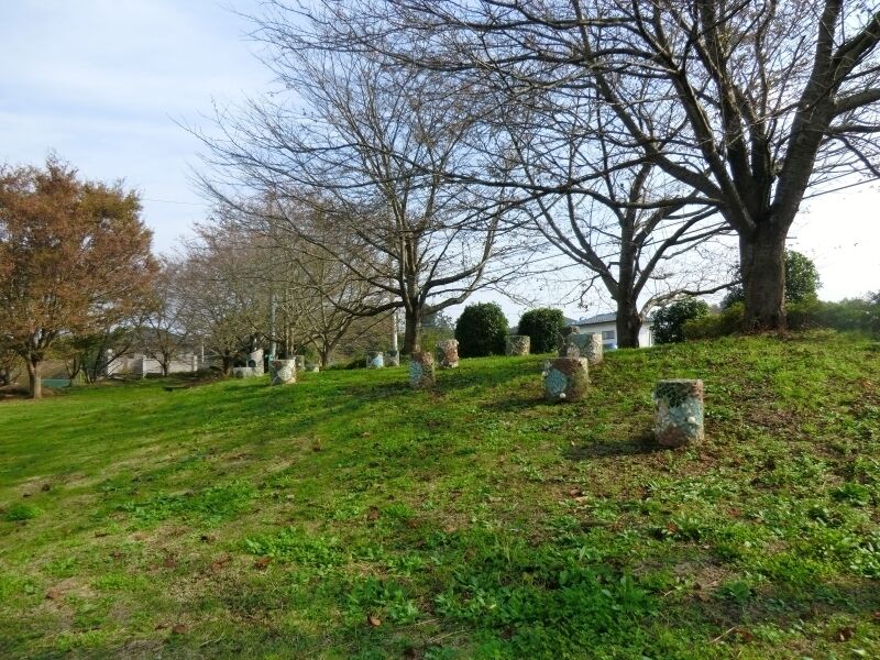 A cemetery with headstones and leafless trees.
