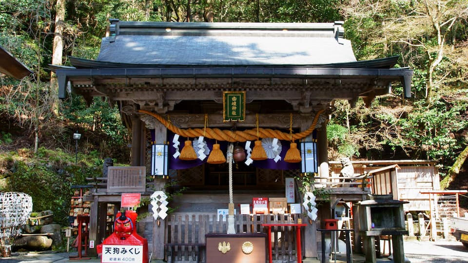 A traditional Japanese shrine surrounded by trees.