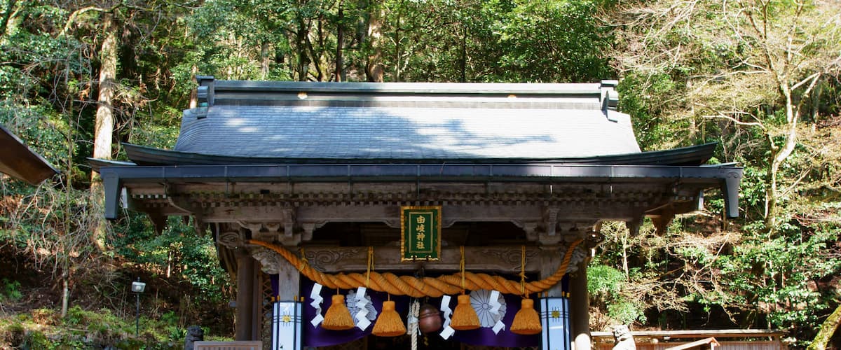 A traditional Japanese shrine surrounded by trees.