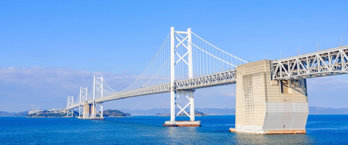 A large suspension bridge with two main towers and cables spanning a body of water.