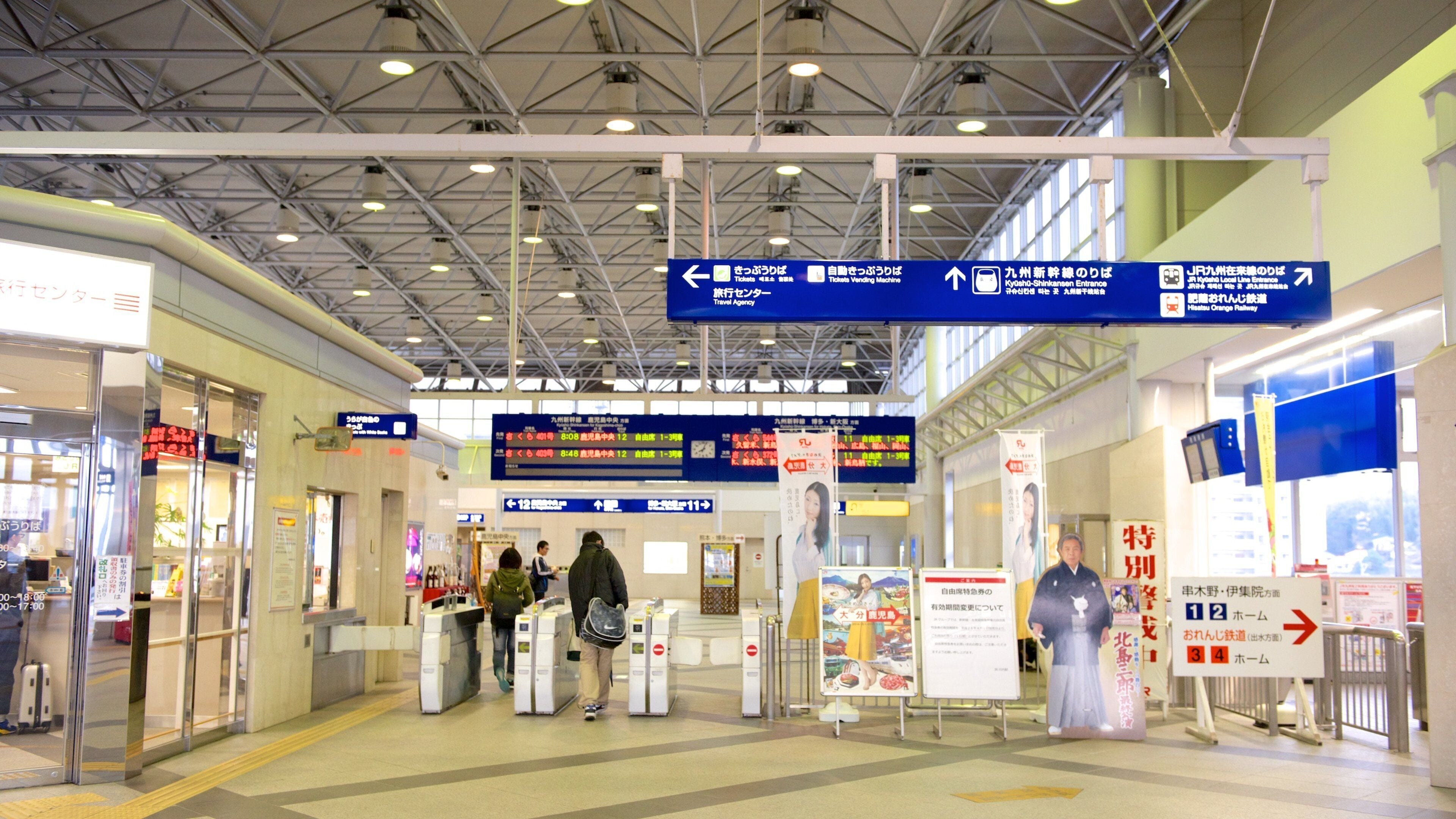 Una estación de tren con señales indicadoras, máquinas expendedoras de billetes y paneles informativos.