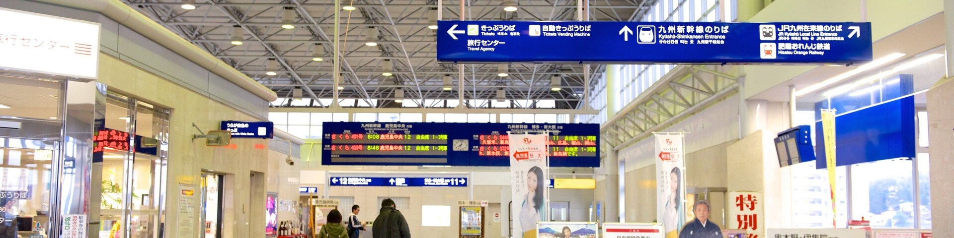 Una estación de tren con señales indicadoras, máquinas expendedoras de billetes y paneles informativos.