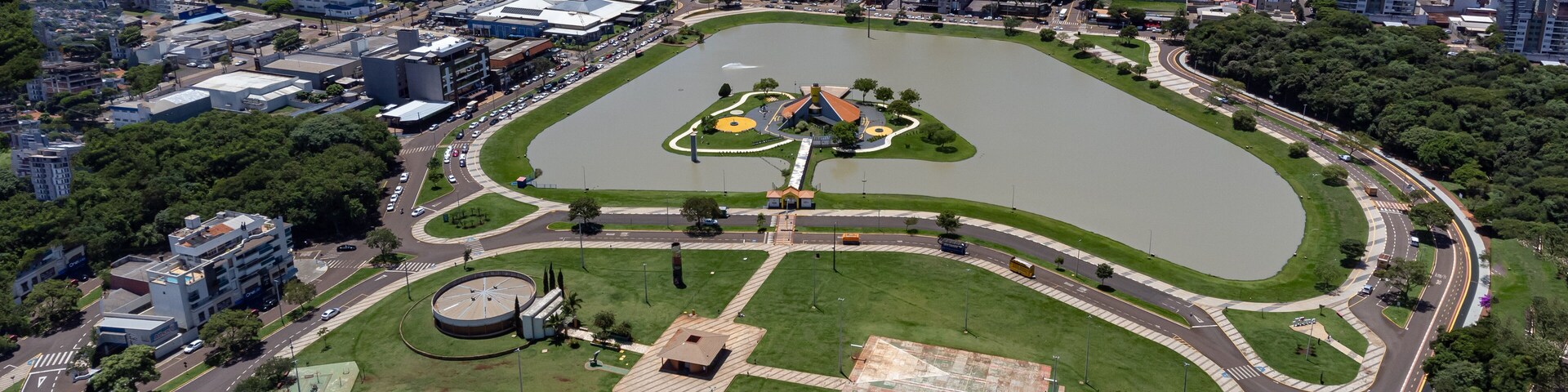 Vista aérea de una ciudad con un gran parque central, un lago y edificios altos a su alrededor.