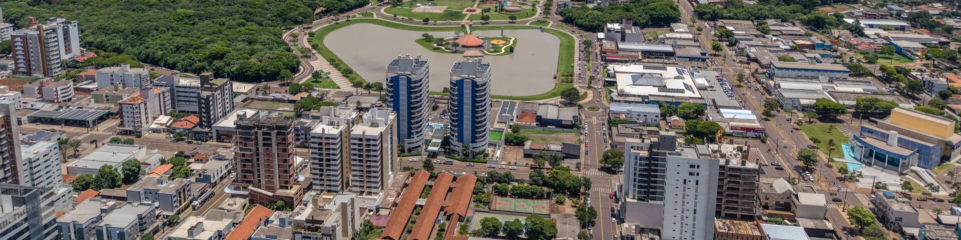 A cityscape with a large park, several high-rise buildings, and a distant view of the countryside.