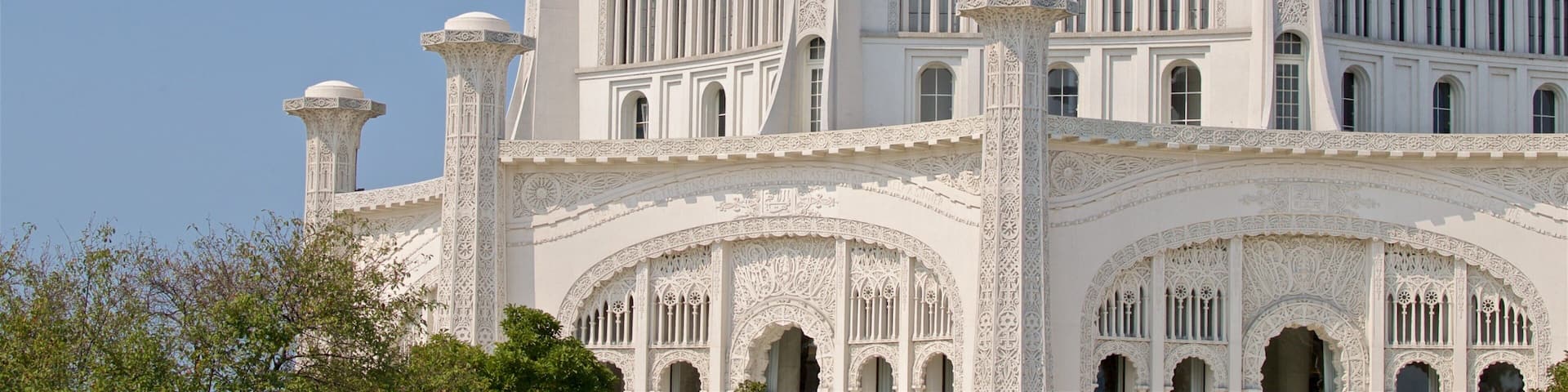 A white, intricately designed building with multiple arches and columns.