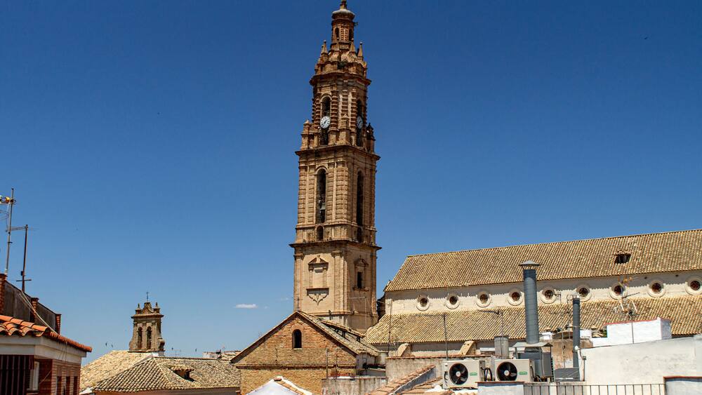 A historic church with a tall bell tower and a tiled roof.