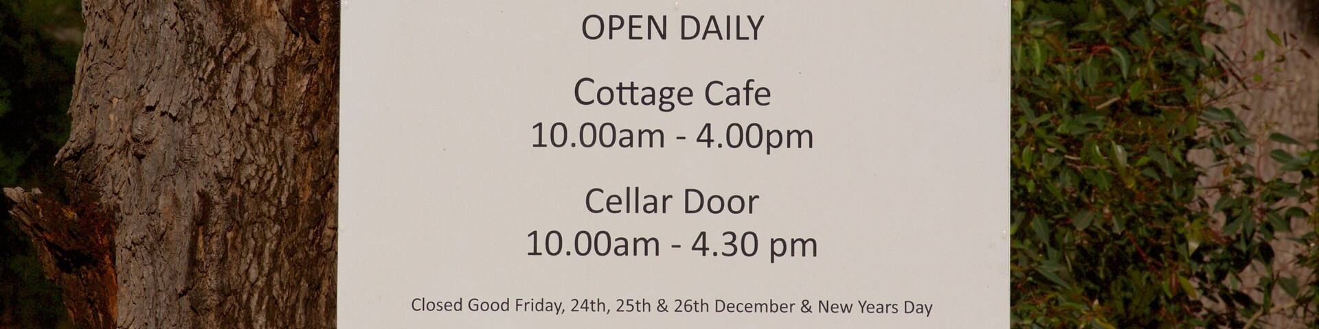 A sign for The Berry Farm, including opening hours for the Cottage Cafe and Cellar Door.
