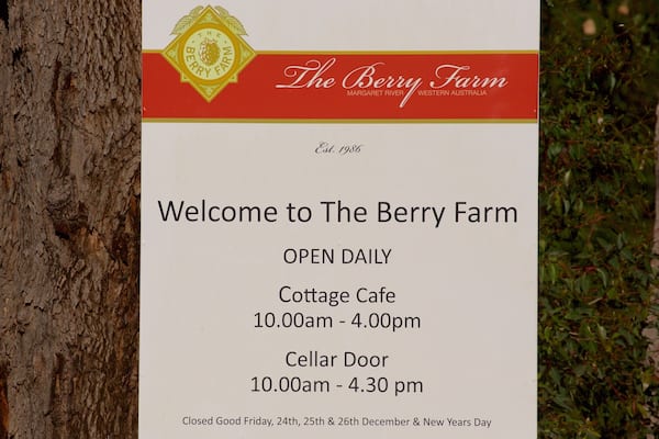 Un panneau indiquant l’emplacement de « The Berry Farm », avec les heures d’ouverture du café et de la boutique de dégustation.