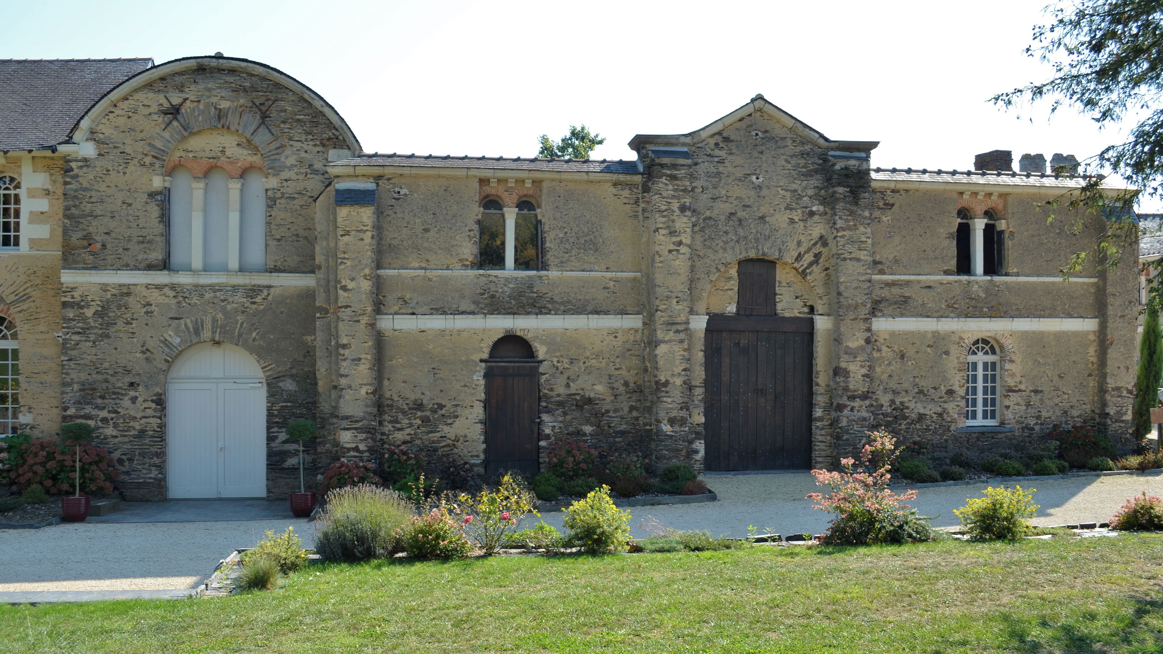 A historic stone building with arched windows and a large central door.