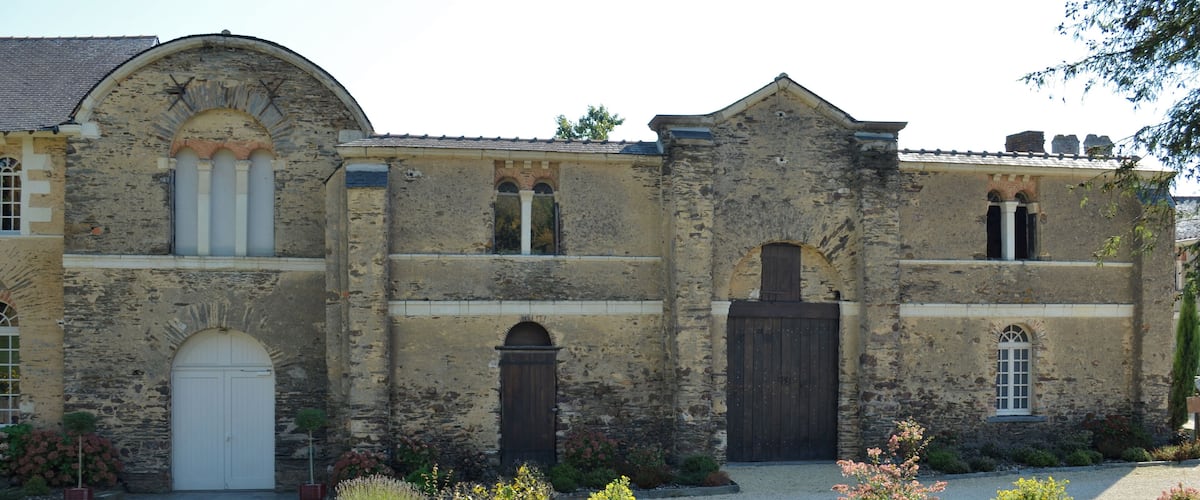 A historic stone building with arched windows and a large central door.