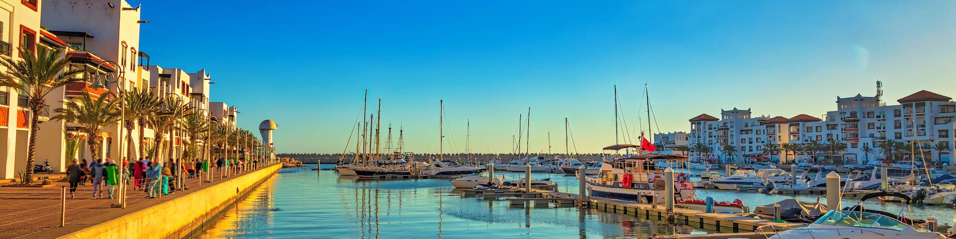 view of the Agadir marina full of tourists, boats and yachts at sunset