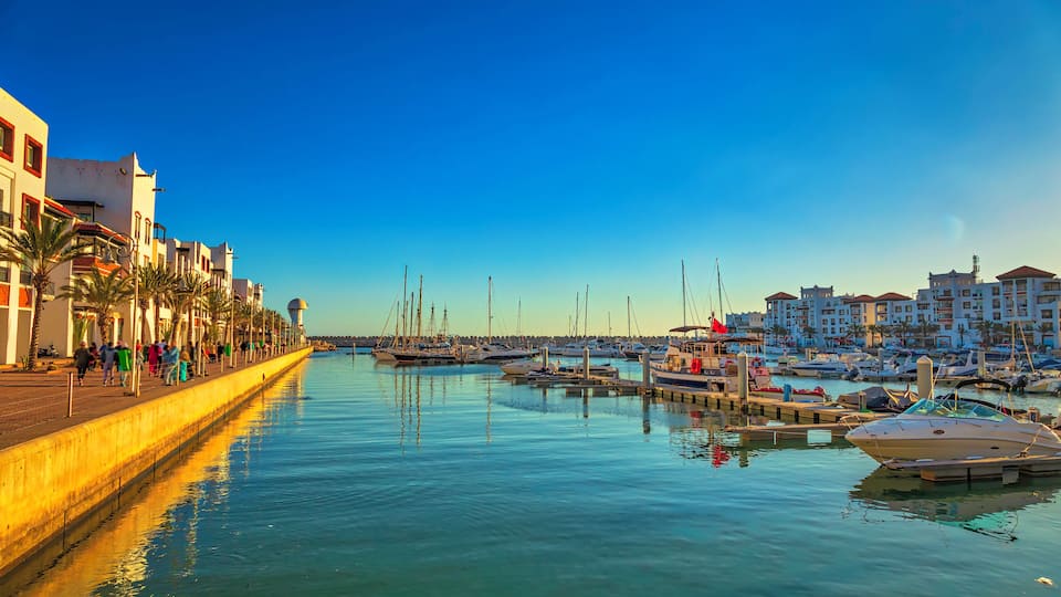 view of the Agadir marina full of tourists, boats and yachts at sunset