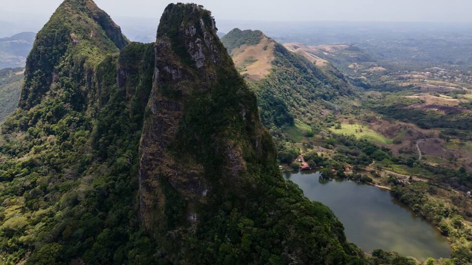 A mountainous landscape with a prominent peak and a lake.