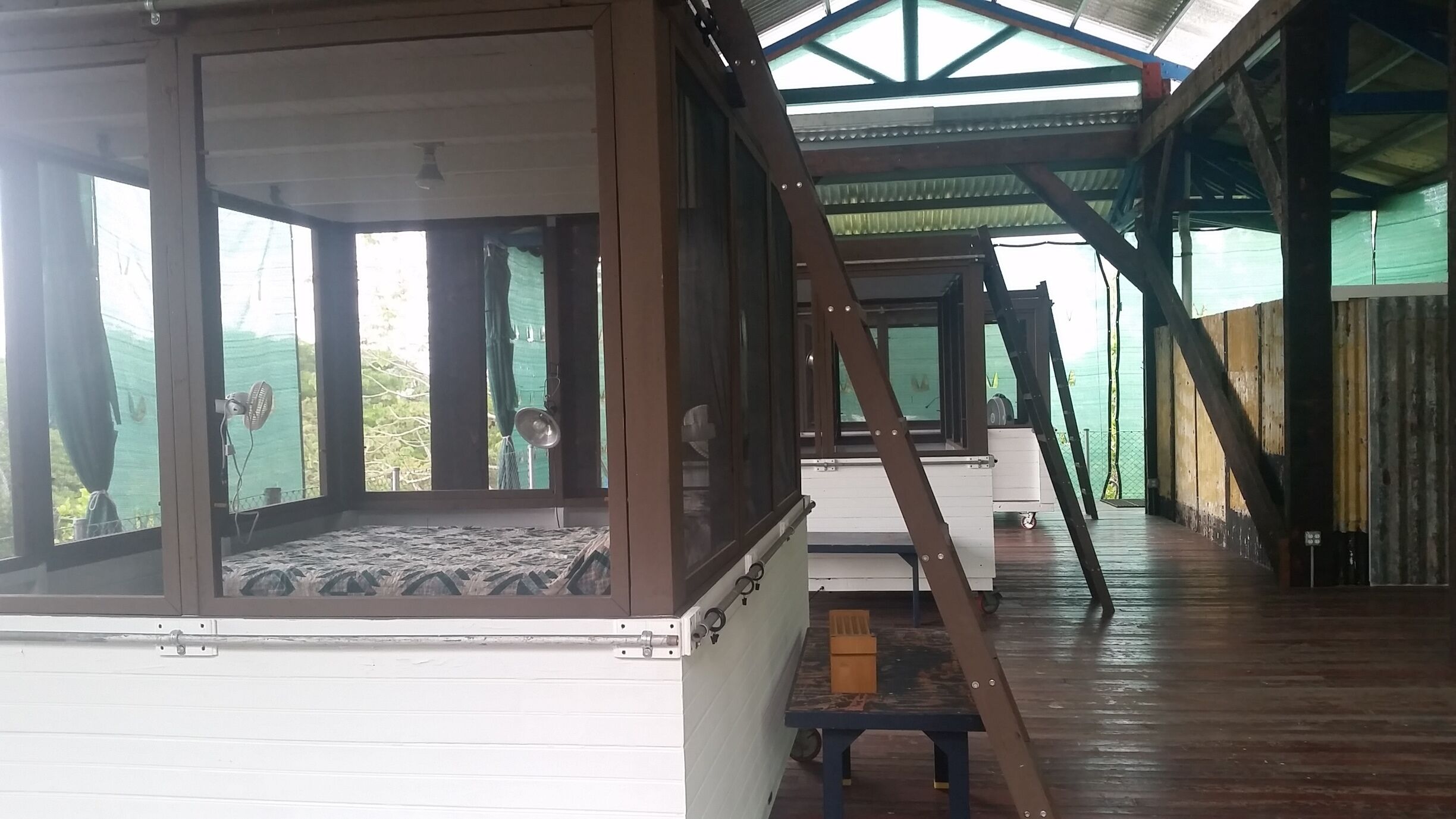 A partially constructed building with exposed wooden beams and a large open window.