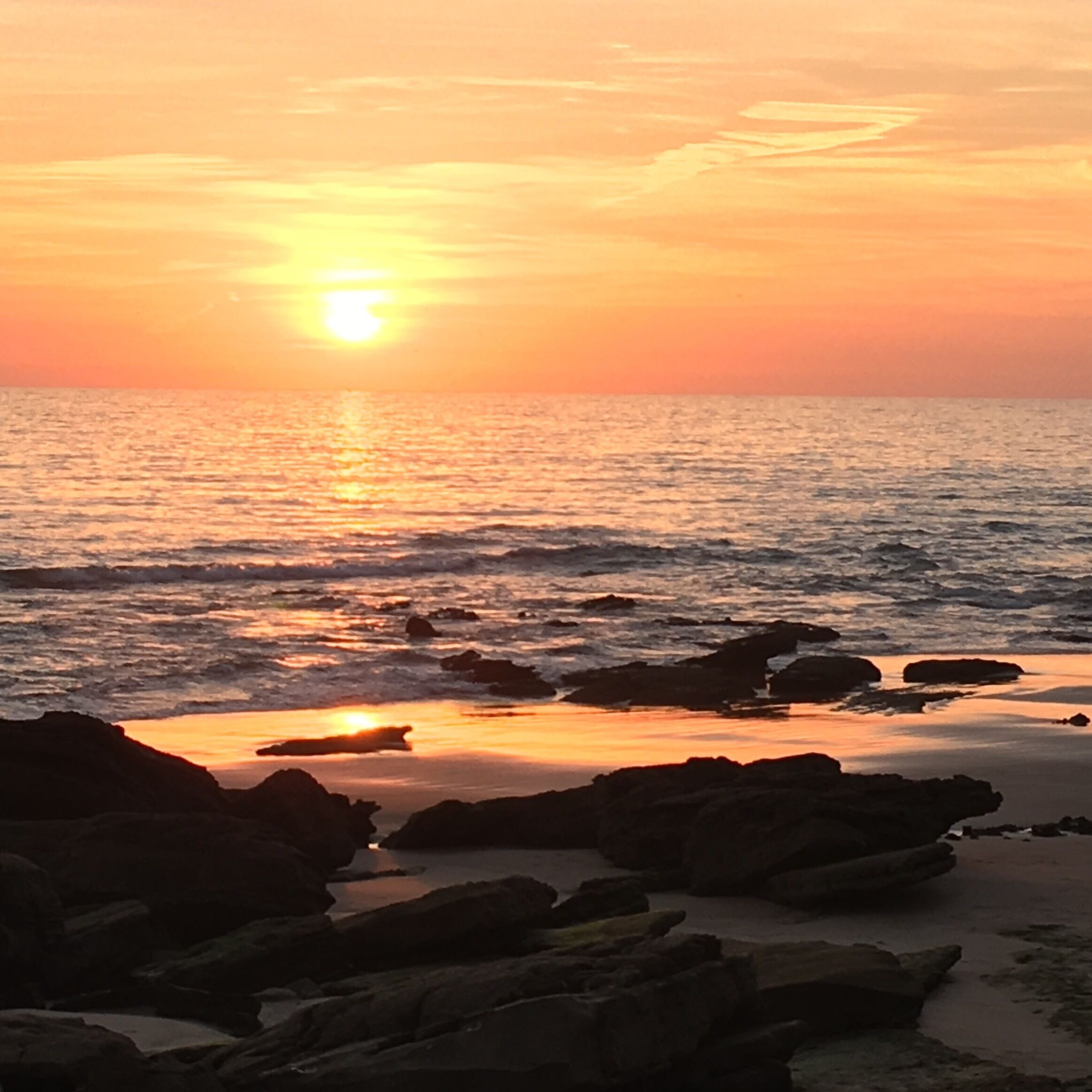At the north side of the strip of cafes in the beach there's a really great bunch of rocks where you can sit and watch the sunset.