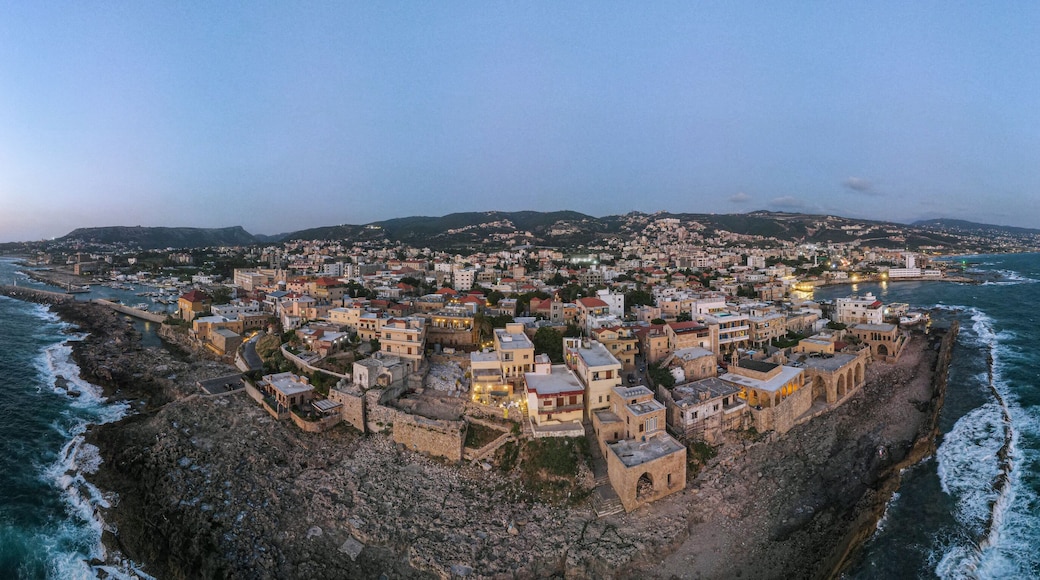 Panoramic sunset view of Batroun, Lebanon, showcasing the coastal city's blend of ancient walls, modern buildings, and picturesque shoreline along the Mediterranean Sea