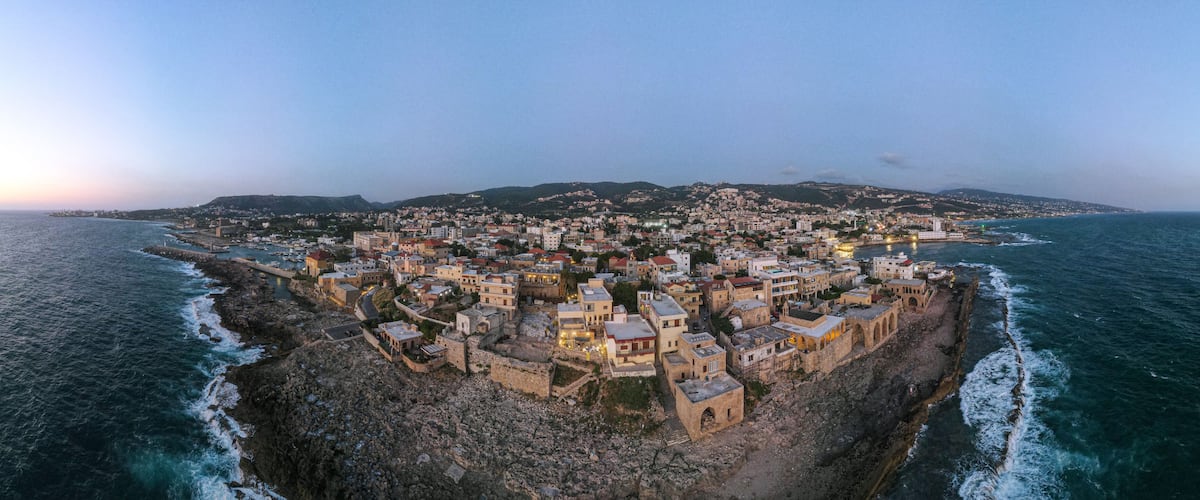 A coastal town with historic buildings and a fortified structure by the sea.