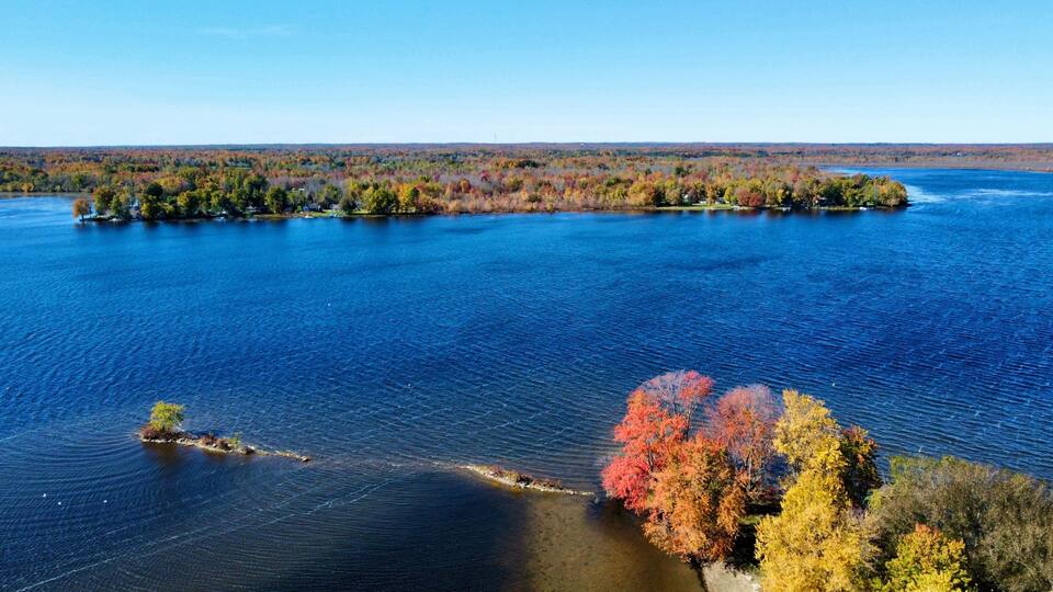 A lake surrounded by autumn-colored trees and a small island.