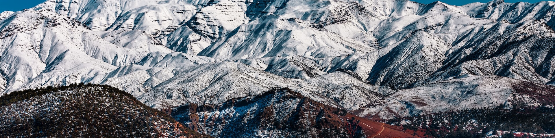 A snow-covered mountain range with a clear blue sky.