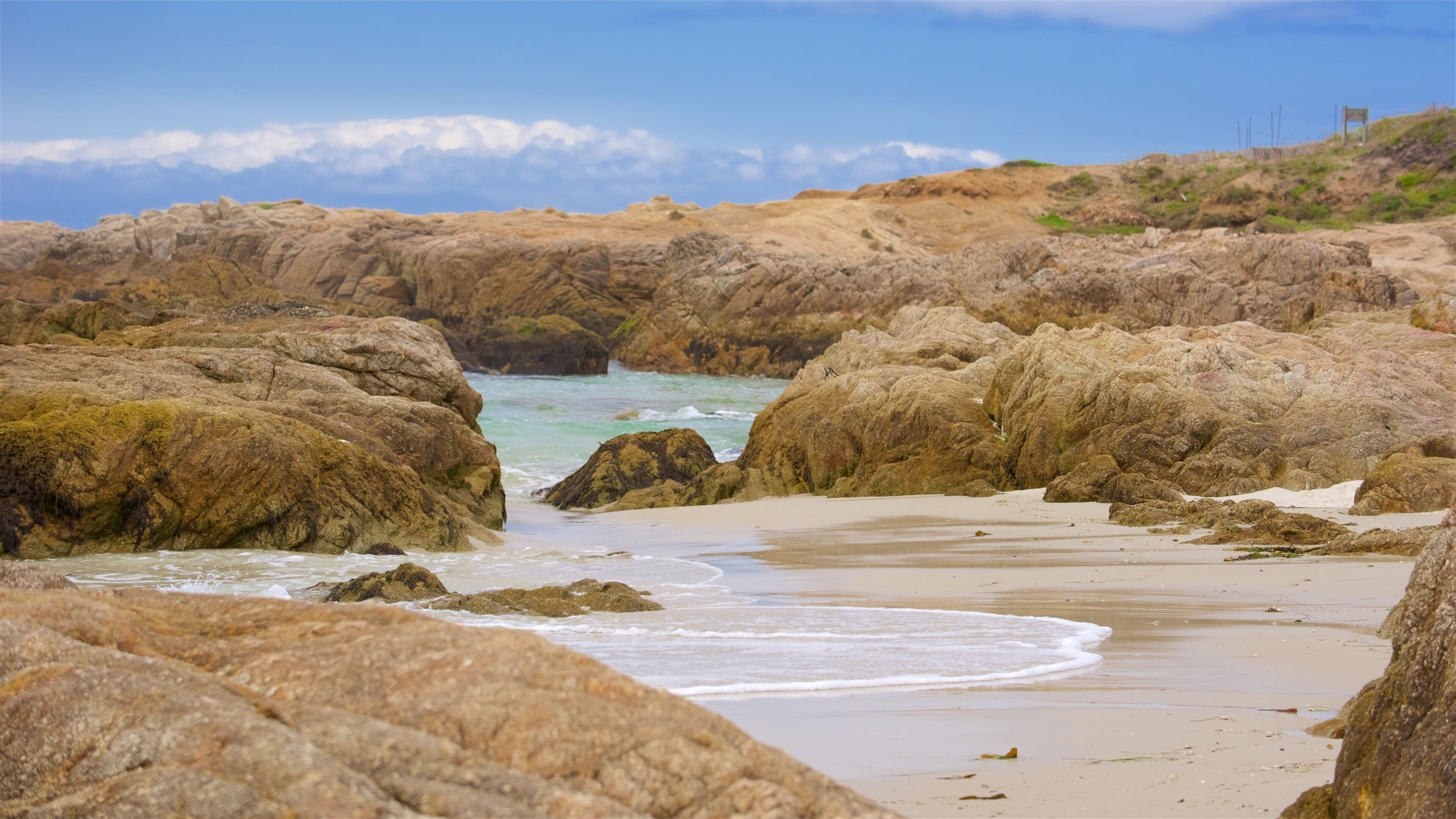 A rocky beach with waves crashing against the shore.