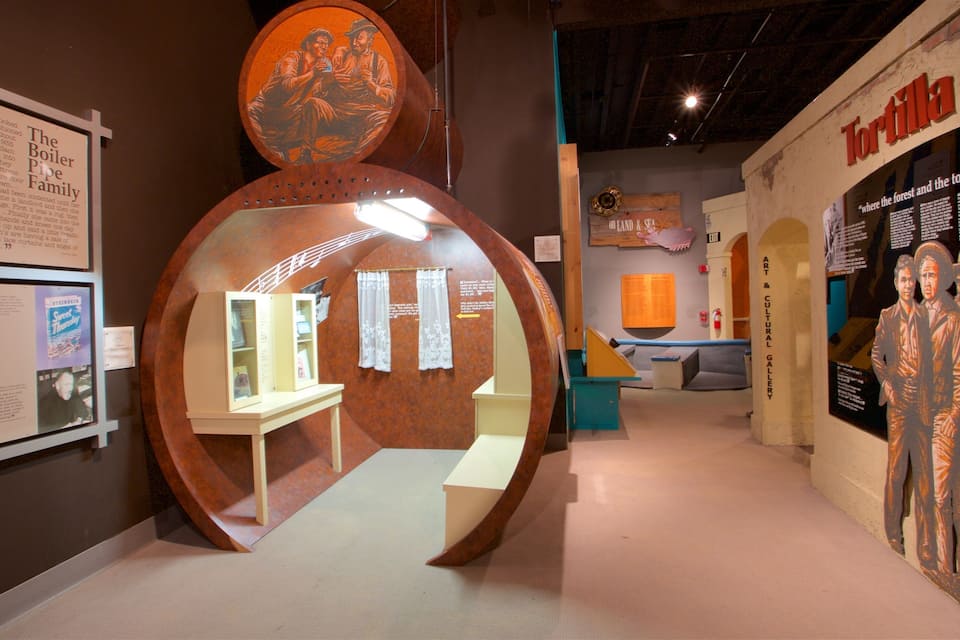 A museum exhibit with a large circular structure, informational plaques, and a 'Tortilla Factory' sign.