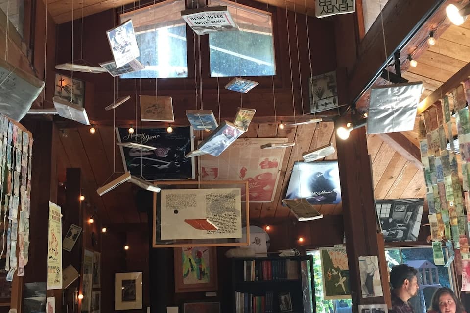 Une librairie avec des plafonds en bois et des livres suspendus.
