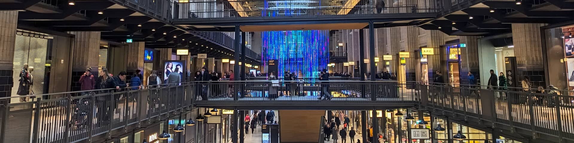Shoppers explore the retail space within the repurposed turbine hall of the Battersea Power Station