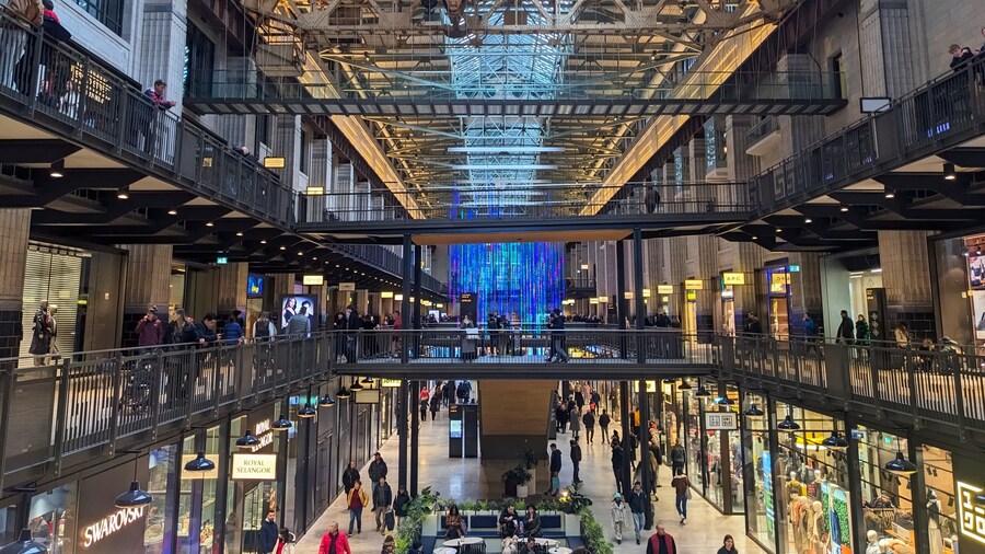 Shoppers explore the retail space within the repurposed turbine hall of the Battersea Power Station