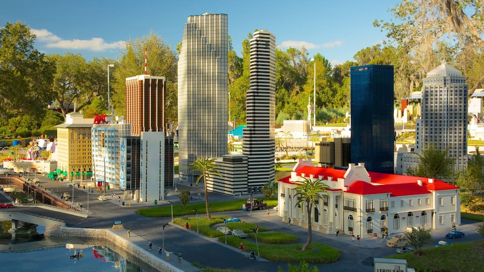 A detailed model of a cityscape with various buildings, including a tall skyscraper, a modern building, and a historic building with a red roof.
