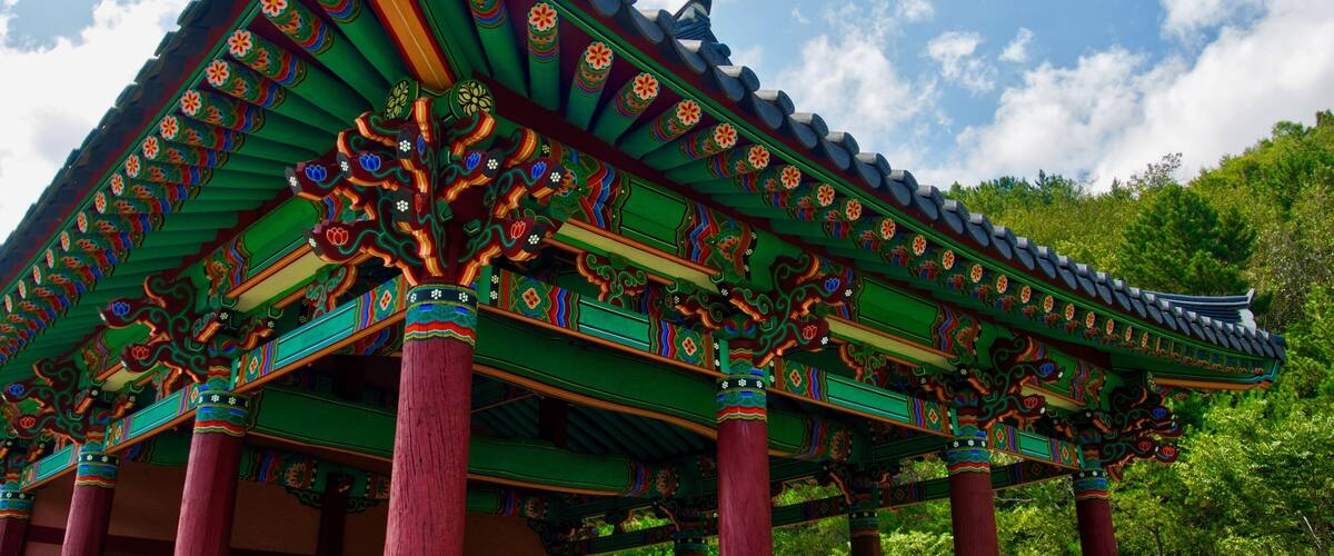 A traditional Korean pavilion with ornate roof decorations and vibrant colors.