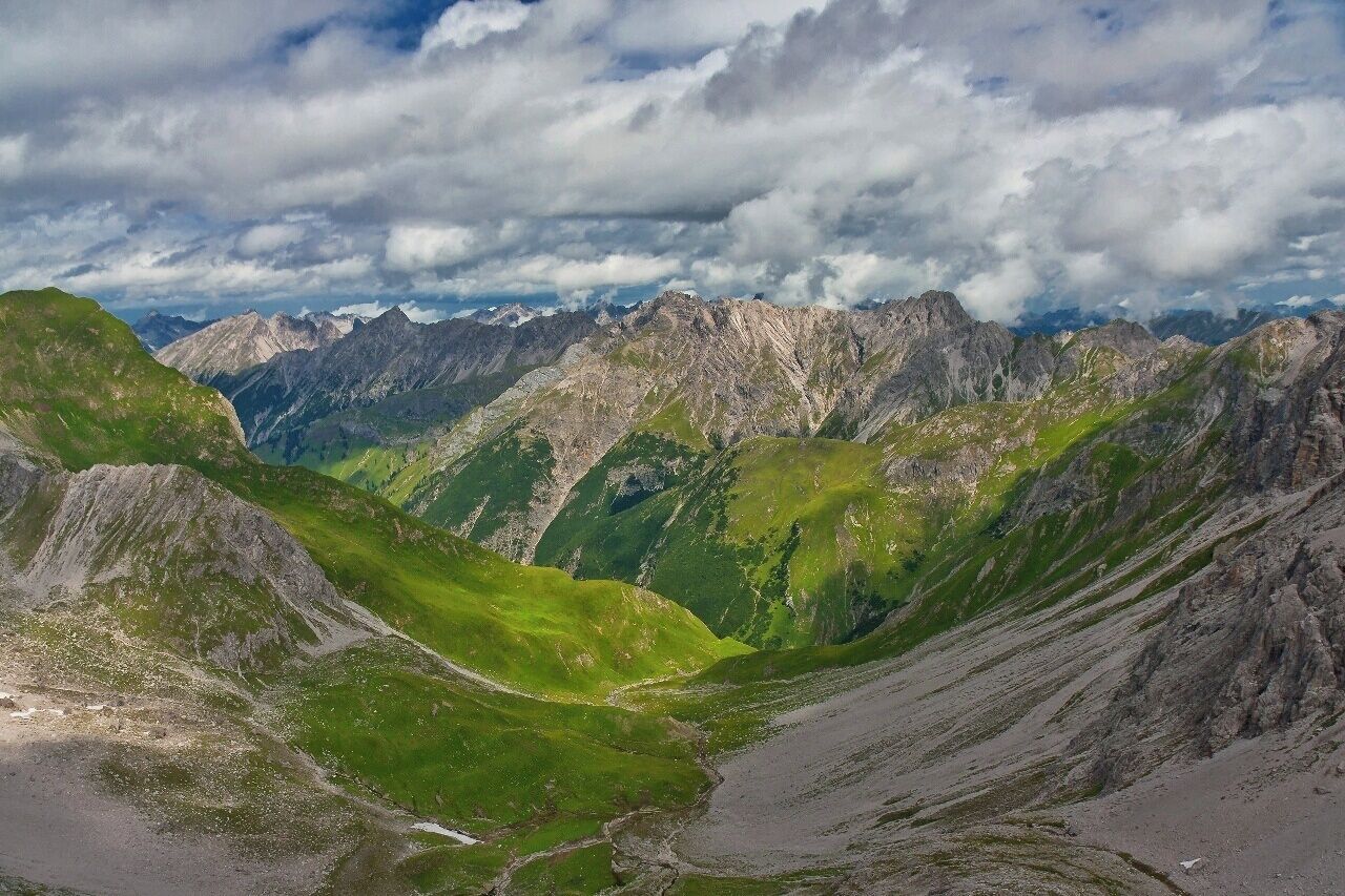 July 2015

Lechtaler Alps, Tyrolia, Austria 

View from Grossberg Kopf (alt. 2.612 m) towards 
Roettal valley over Madau village. In the middle are the passes
Am Nocken  (2.032 m) and 
Streichgampenjoechl (2.221 m). The summits are
Hengstspitzen (2.539 to 2.599 m) and
Landschaftseck ( 2.610 m). You will go through this valley when trekking from
Memminger Huette to Gramais or Madau. 

It is a typical scenery of Lechtaler Alps with lush green meadows and light grey limestone ranges over them. 