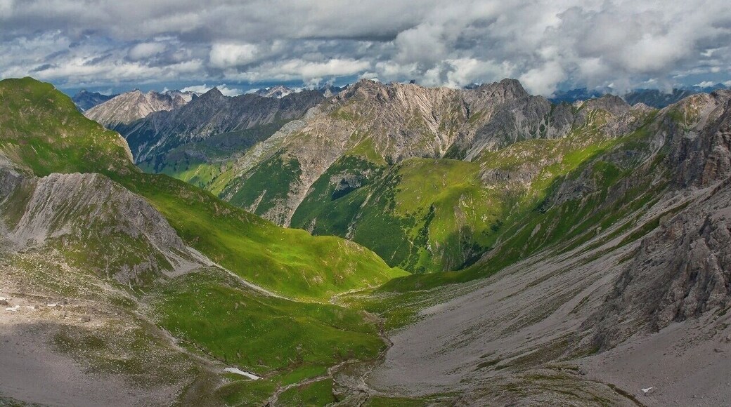 July 2015
Lechtaler Alps, Tyrolia, Austria
View from Grossberg Kopf (alt. 2.612 m) towards
Roettal valley over Madau village. In the middle are the passes
Am Nocken (2.032 m) and
Streichgampenjoechl (2.221 m). The summits are
Hengstspitzen (2.539 to 2.599 m) and
Landschaftseck ( 2.610 m). You will go through this valley when trekking from
Memminger Huette to Gramais or Madau.
It is a typical scenery of Lechtaler Alps with lush green meadows and light grey limestone ranges over them.