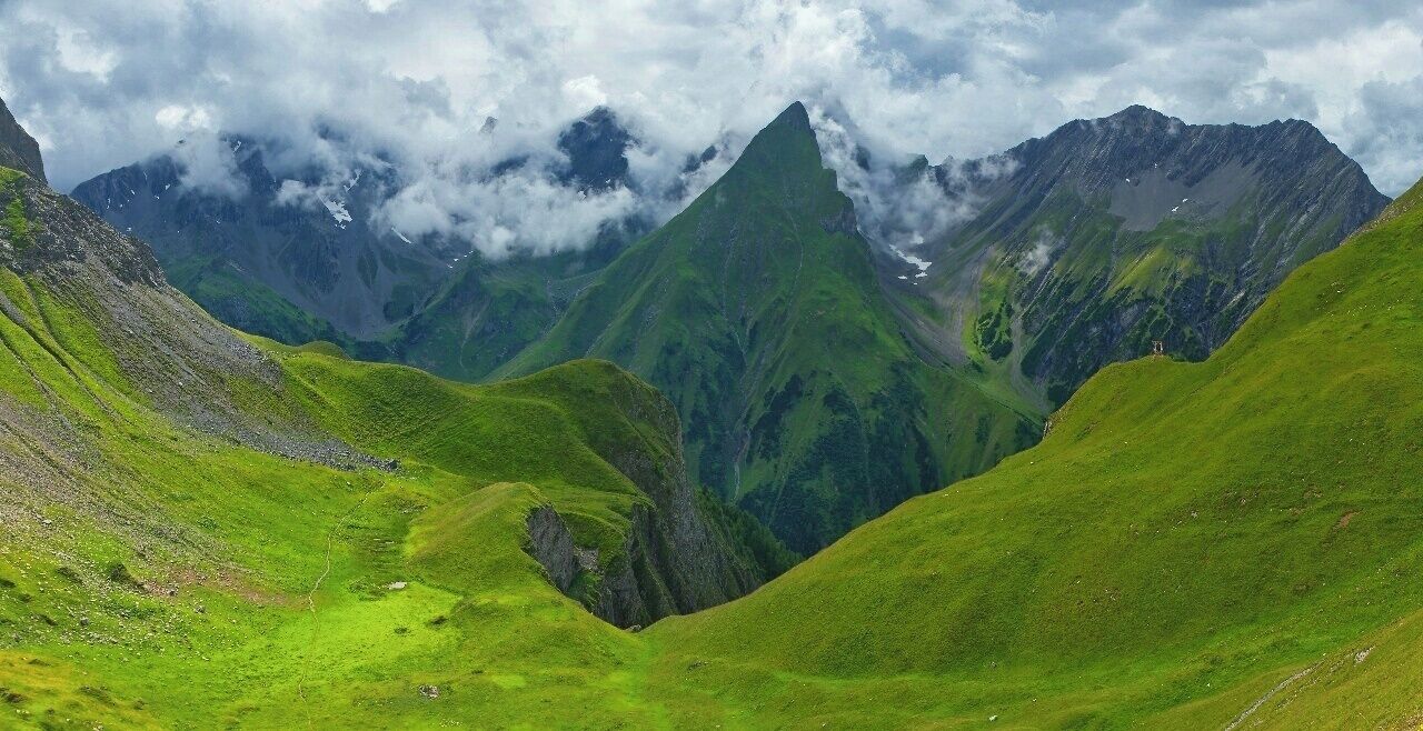 July 2015 

Freispitze, Lechtaler Alps 

View of the Parseier Tal (=valley) canyon from Memminger Huette (2.242 m alt.). In the middle the slope of Freispitze summit (2.884 m) and on the right Saxer Spitze summit (2.690 m). In the middle of summer afternoon clouds  bring rain and sun sometimes illuminates the rich green meadows around the hut.