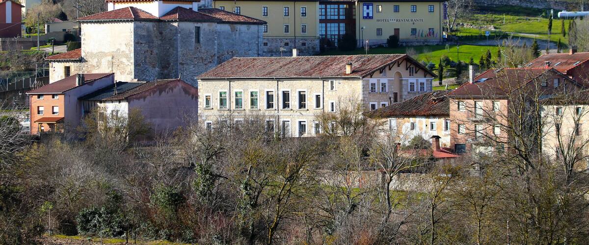 A historic town with a prominent church, a hotel, and surrounding greenery.