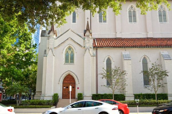 A church with a red-tiled roof and arched windows.