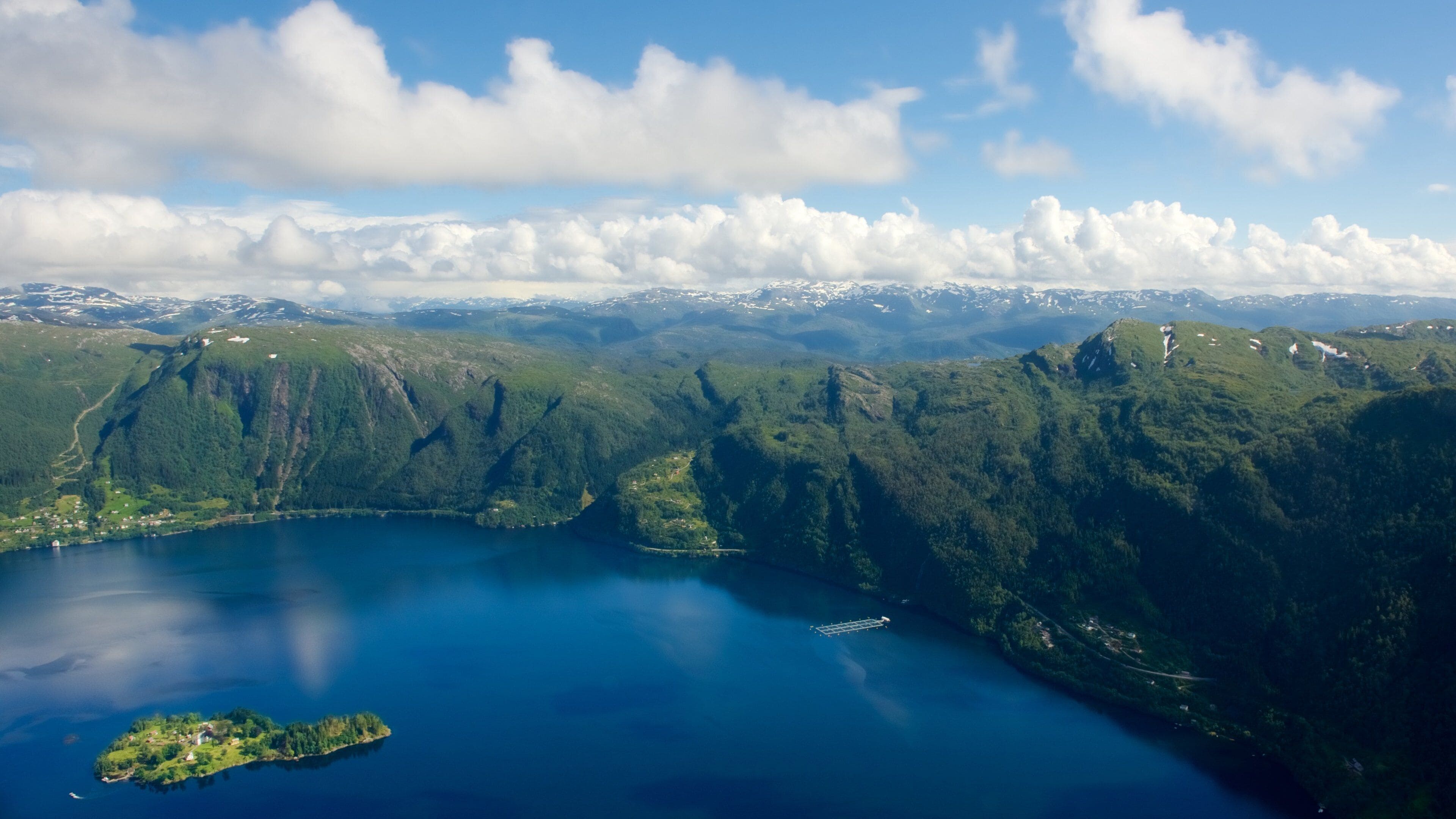 A mountainous landscape with a lake and a small island.