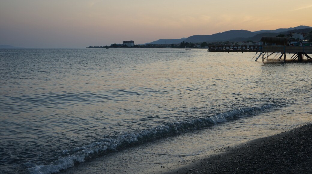 Blick vom Strand in Altinoluk im romantischen Licht der untergehenden Sonne auf den Golf von Edremit am Ägäischen Meer in der Provinz Balikesir in der Türkei