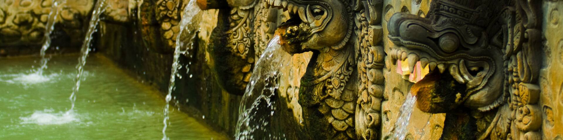 Thermal water shooting into a bathing pool from the mouths of dragon statues at a hot springs in Banjar, Bali, Indonesia. Horizontal; Shutterstock ID 65274505; Purchase Order: -