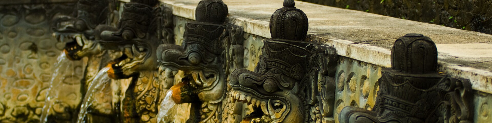 Thermal water shooting into a bathing pool from the mouths of dragon statues at a hot springs in Banjar, Bali, Indonesia. Horizontal; Shutterstock ID 65274505; Purchase Order: -